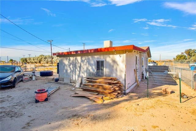 view of outbuilding featuring fence