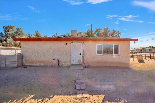 back of house with fence and stucco siding