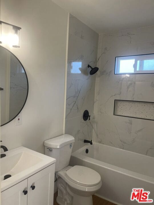 full bathroom featuring toilet, vanity, and tiled shower / bath combo