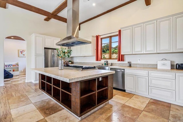 kitchen featuring white cabinetry, beamed ceiling, island range hood, a kitchen island, and appliances with stainless steel finishes