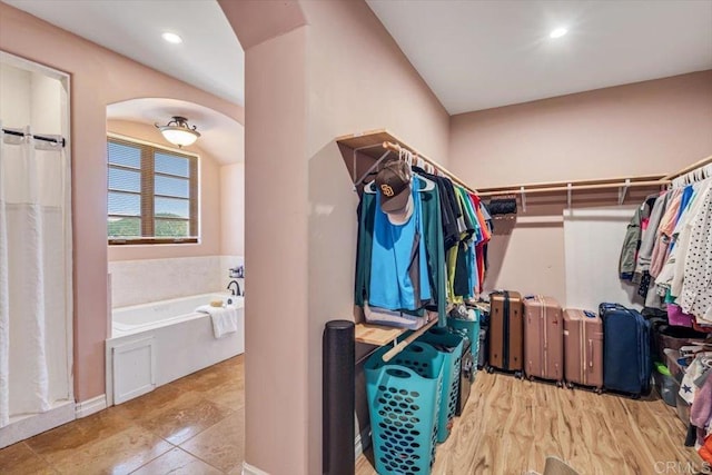 walk in closet with light tile patterned floors