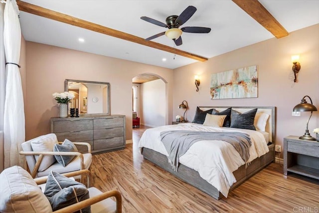 bedroom featuring ceiling fan, beam ceiling, and light wood-type flooring