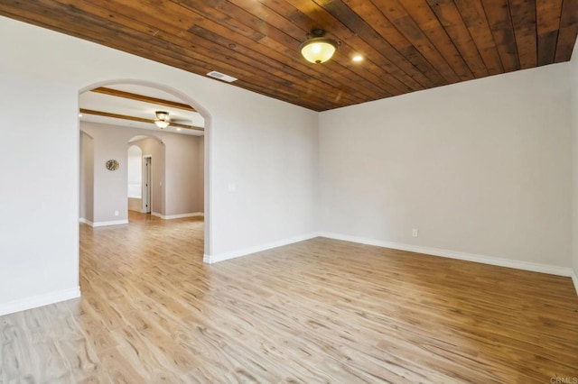 unfurnished room with arched walkways, visible vents, wood ceiling, light wood-type flooring, and baseboards