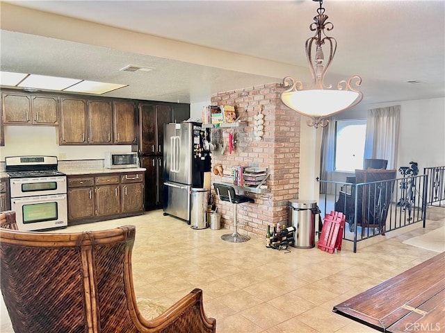 kitchen with dark brown cabinets, stainless steel appliances, and hanging light fixtures