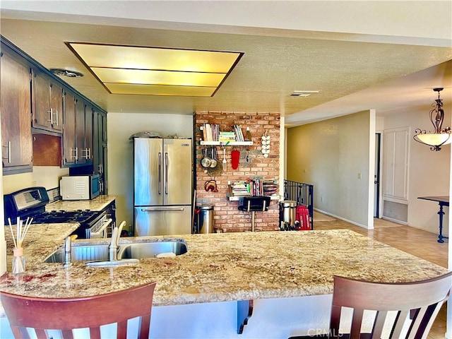 kitchen featuring a textured ceiling, sink, kitchen peninsula, and stainless steel appliances