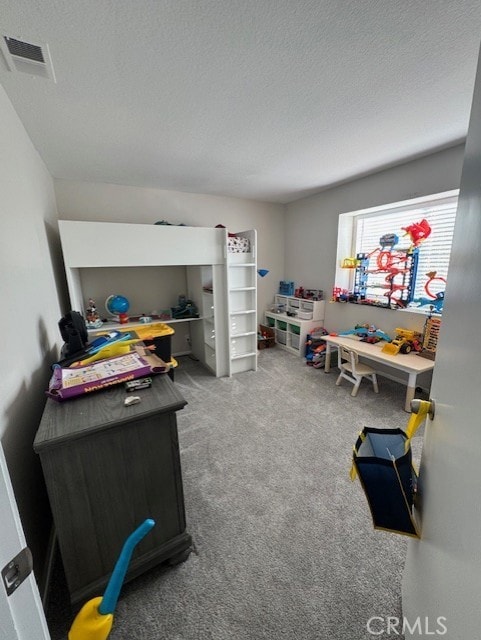 game room with a textured ceiling and carpet floors