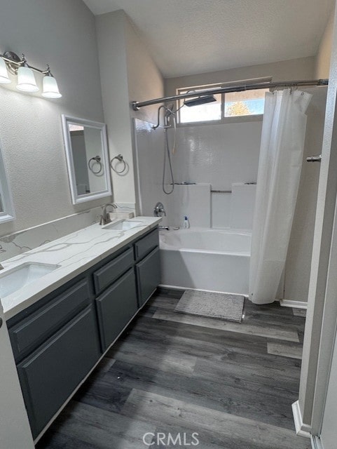 bathroom with shower / bath combination with curtain, vanity, wood-type flooring, and a textured ceiling