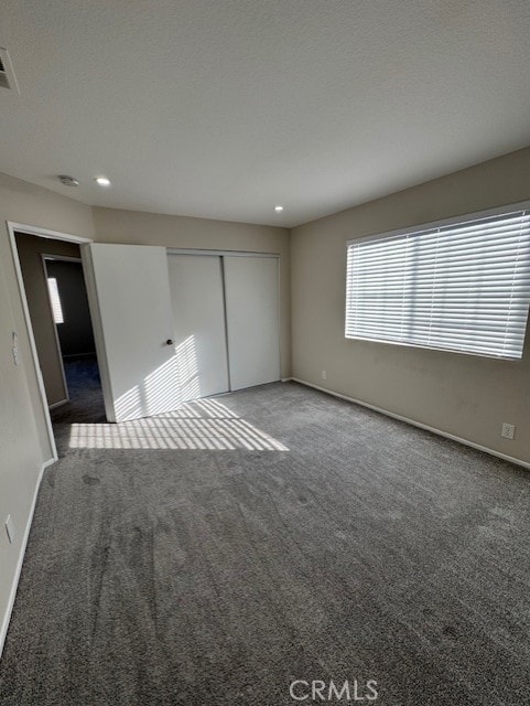 unfurnished bedroom featuring carpet floors and a closet