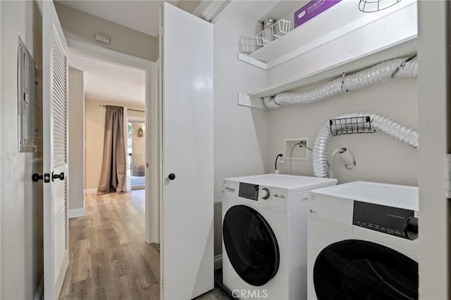 clothes washing area featuring light wood-type flooring and washing machine and clothes dryer