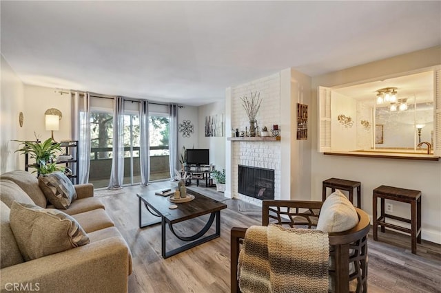 living room featuring hardwood / wood-style flooring and a brick fireplace