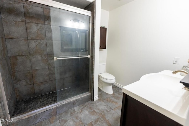 bathroom with vanity, toilet, and a shower with shower door