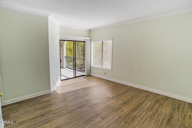 spare room with ornamental molding and dark wood-type flooring