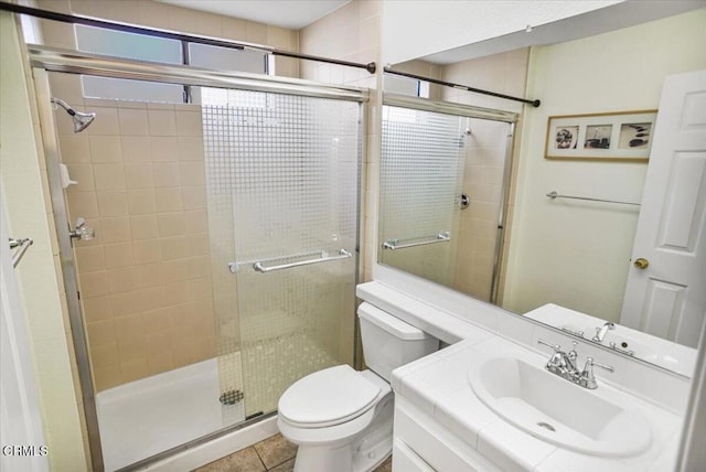 bathroom featuring tile patterned floors, vanity, toilet, and walk in shower