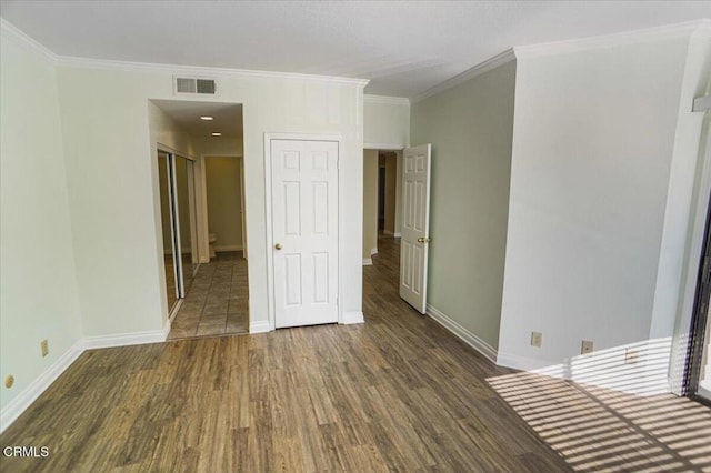 spare room featuring crown molding and dark hardwood / wood-style flooring