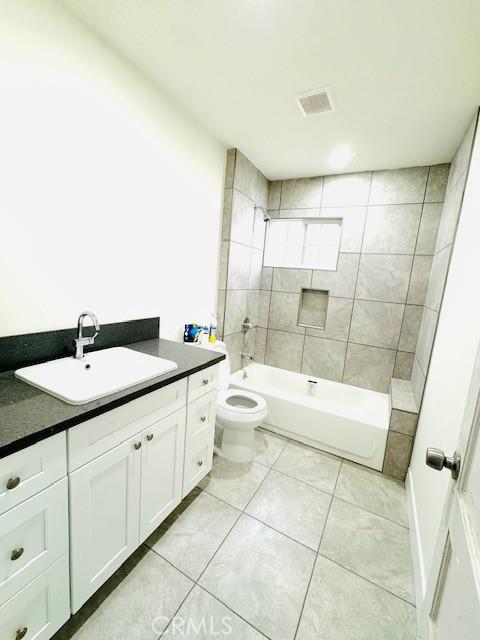 bathroom with toilet, tile patterned flooring, shower / tub combination, and vanity