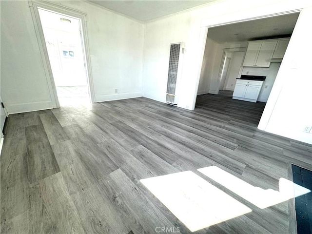 unfurnished living room with light wood-style flooring and baseboards