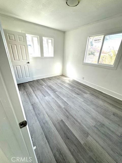 interior space featuring dark wood-style floors, a textured ceiling, and baseboards