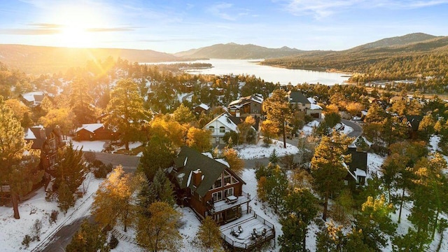 snowy aerial view with a water and mountain view