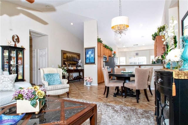 tiled living room featuring ceiling fan with notable chandelier and high vaulted ceiling