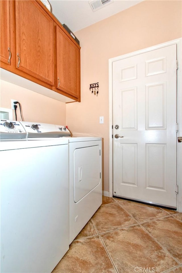 laundry room featuring light tile patterned flooring, cabinets, and independent washer and dryer