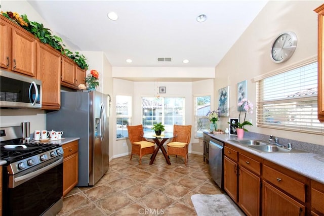 kitchen with light tile patterned floors, stainless steel appliances, vaulted ceiling, and sink