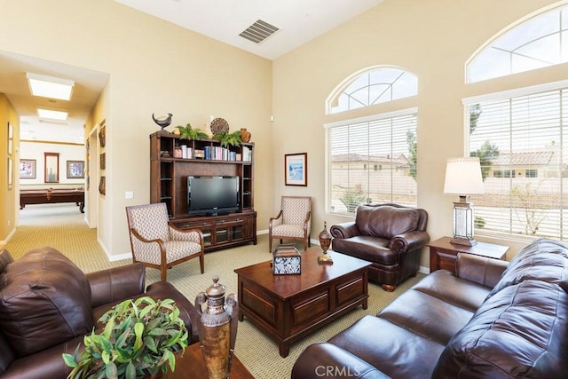 living area featuring visible vents, a towering ceiling, light carpet, billiards, and baseboards