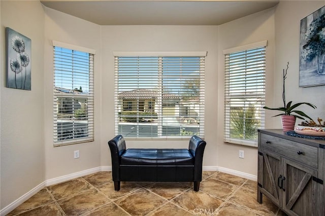 living area featuring tile patterned flooring and baseboards