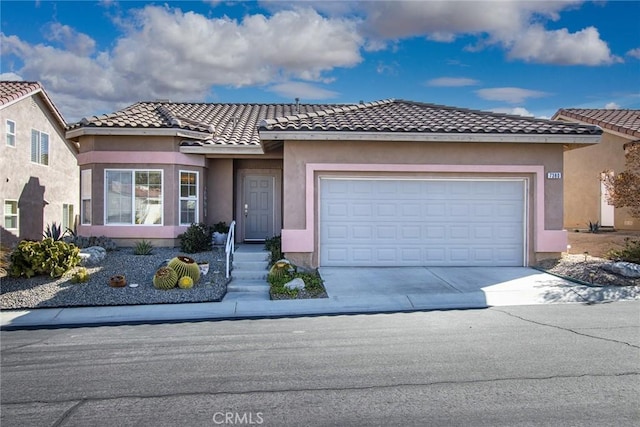 view of front of property with a garage, concrete driveway, a tiled roof, and stucco siding