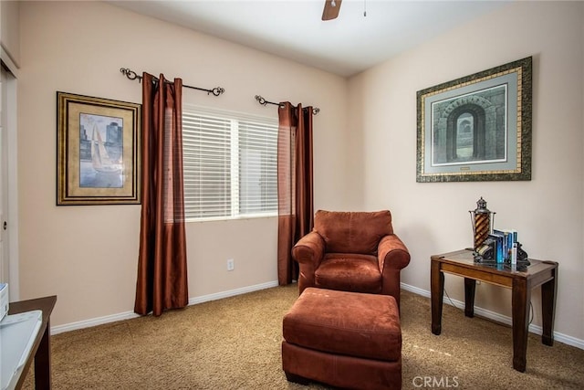 living area featuring light carpet, ceiling fan, and baseboards