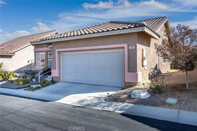 view of front of property with a garage, driveway, a tile roof, and stucco siding