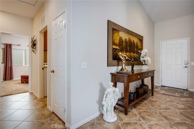 foyer entrance with light tile patterned flooring, visible vents, and baseboards