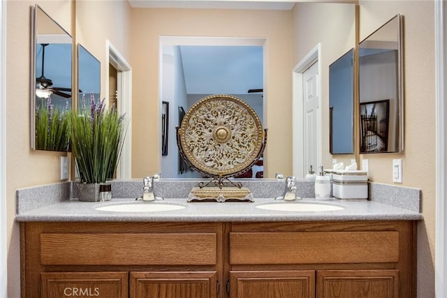 bathroom featuring ceiling fan, a sink, and double vanity