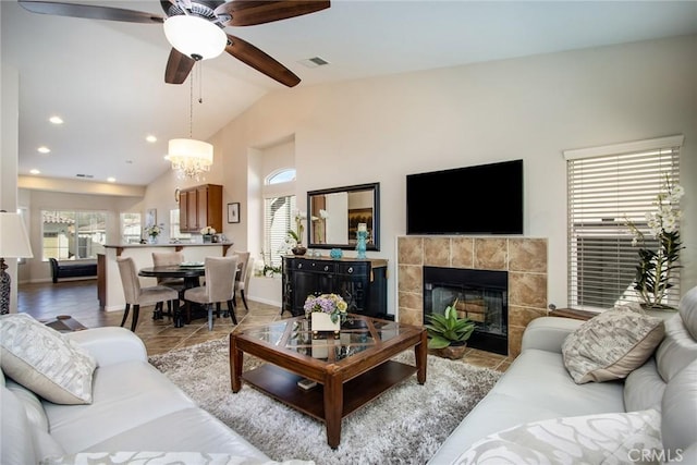 living area with lofted ceiling, a fireplace, a wealth of natural light, and light tile patterned flooring