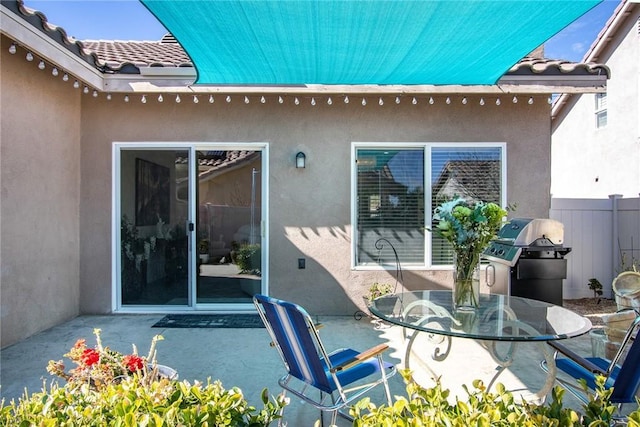 view of patio with a grill and fence