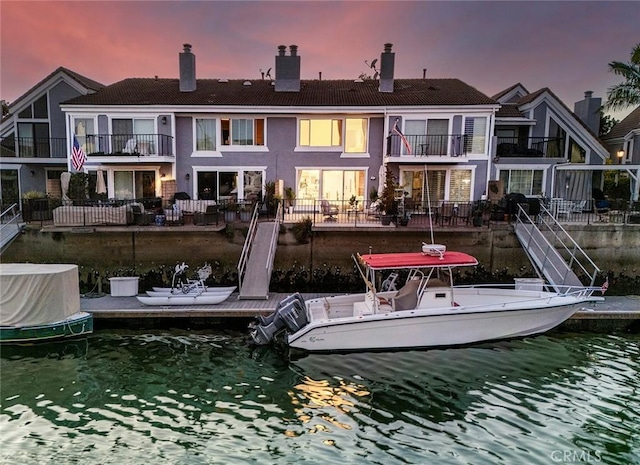 back house at dusk featuring a water view