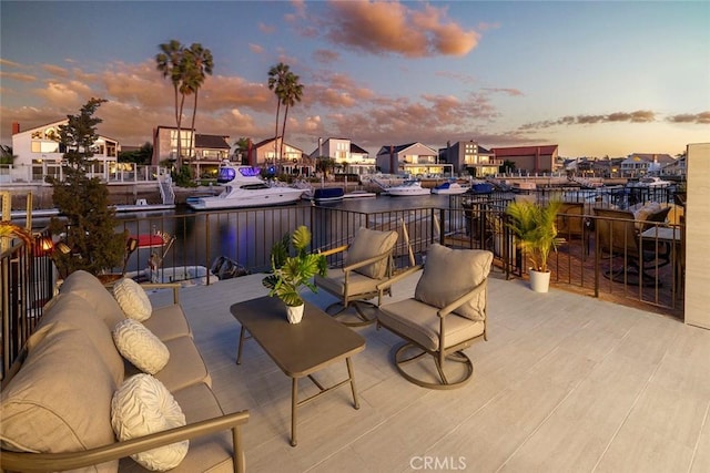 patio terrace at dusk featuring outdoor lounge area and a water view