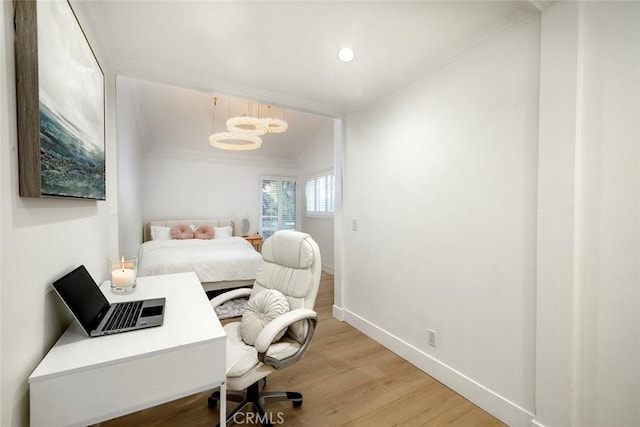 bedroom featuring a notable chandelier, light hardwood / wood-style floors, lofted ceiling, and ornamental molding