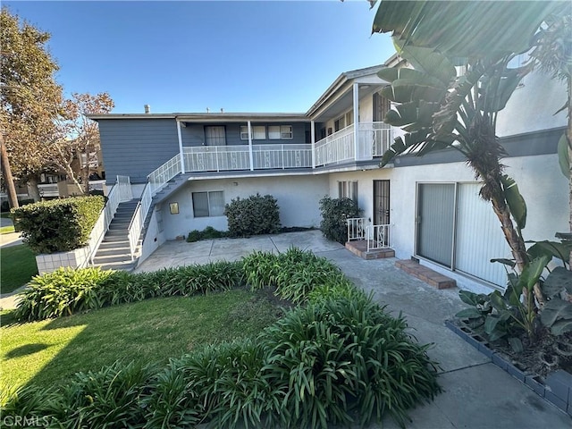 back of property with a lawn and a patio area