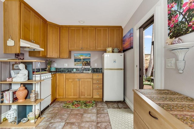 kitchen featuring white refrigerator, range, and sink