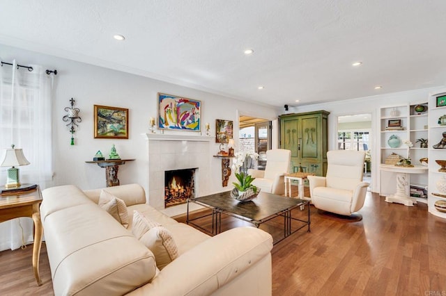 living room with a fireplace, crown molding, and hardwood / wood-style floors