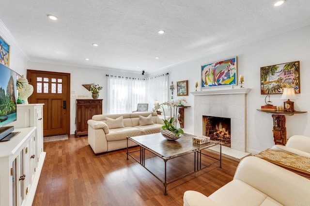 living room featuring light hardwood / wood-style floors, a wealth of natural light, crown molding, and a fireplace