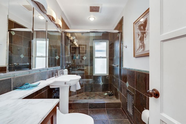 bathroom with toilet, tile walls, and an enclosed shower