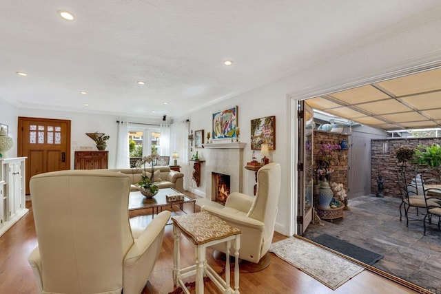 living room featuring wood-type flooring, ornamental molding, and french doors