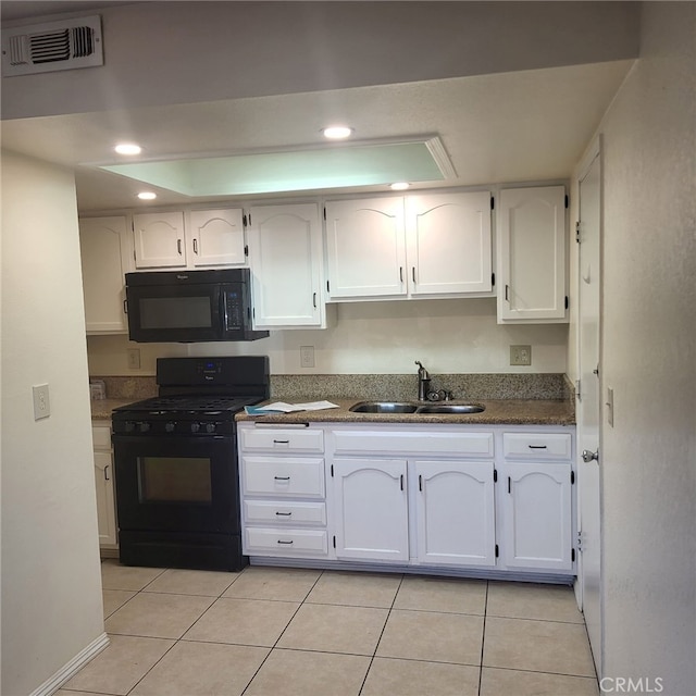 kitchen featuring sink, white cabinetry, light tile patterned floors, and black appliances