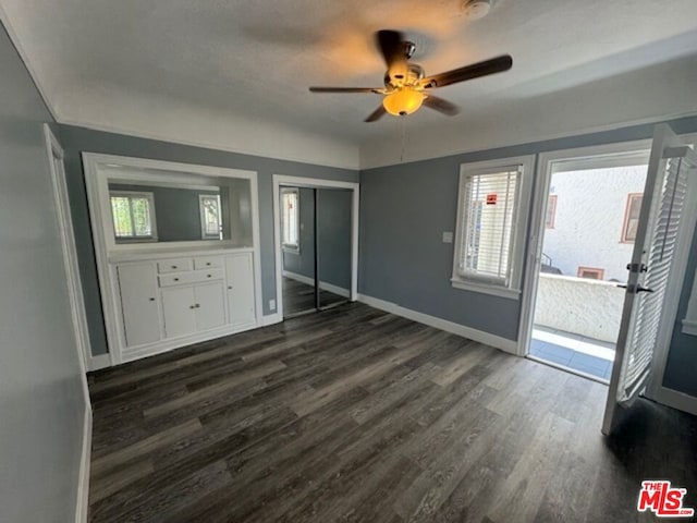 unfurnished bedroom featuring ceiling fan and dark wood-type flooring