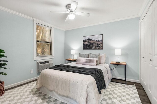 bedroom featuring an AC wall unit, crown molding, ceiling fan, wood-type flooring, and a closet