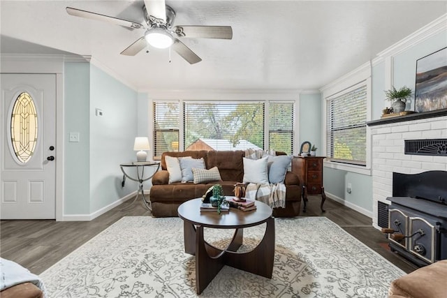 living room featuring ceiling fan, crown molding, a wood stove, and dark wood-type flooring