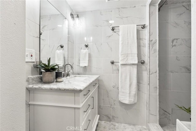 bathroom featuring vanity and tiled shower