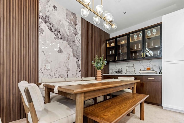 dining area featuring light carpet and an inviting chandelier