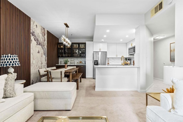 living room featuring sink and light carpet